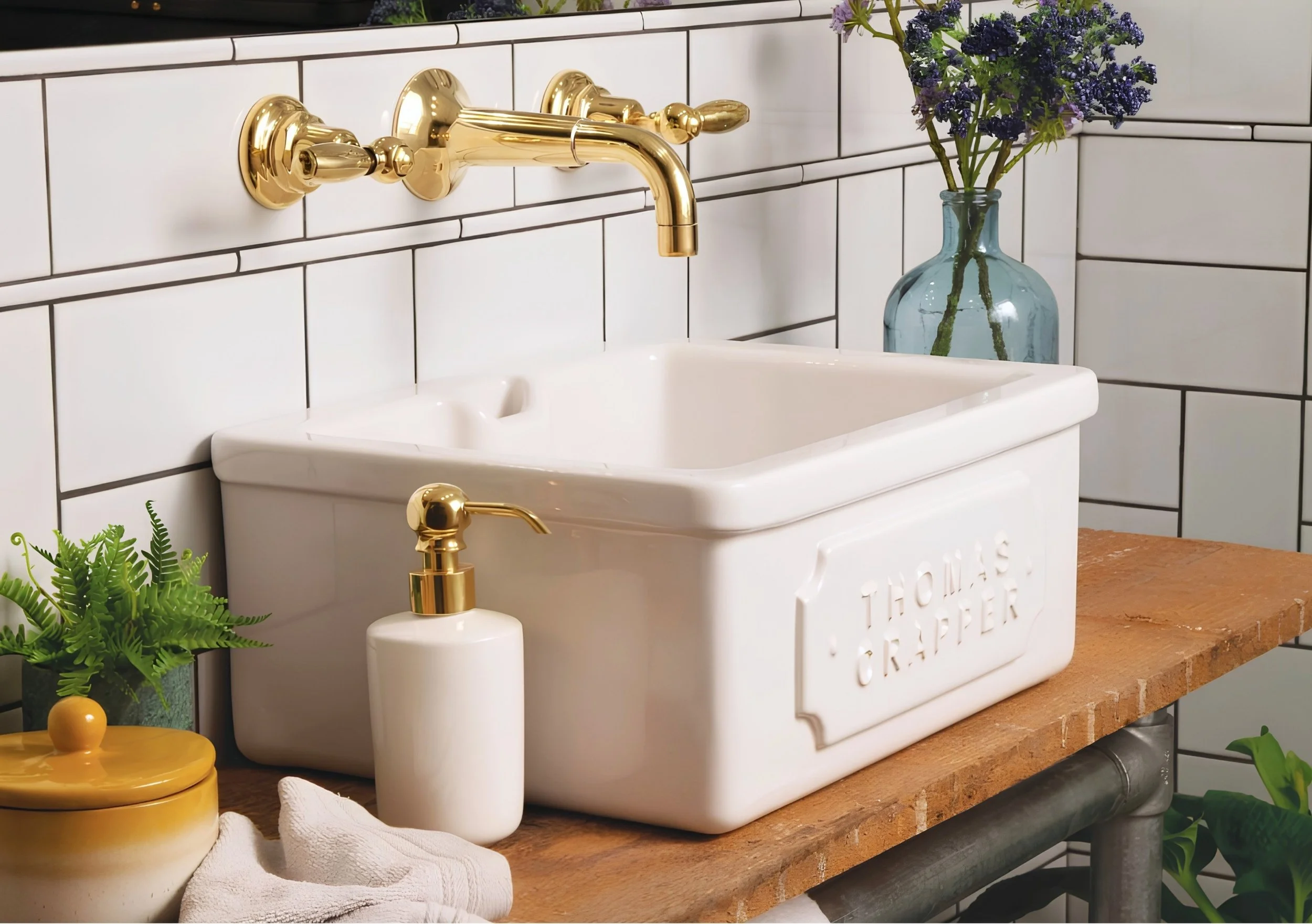 Thomas Crapper Belfast ceramic sink with polished brass wall-mounted mixer tap in a traditional kitchen.