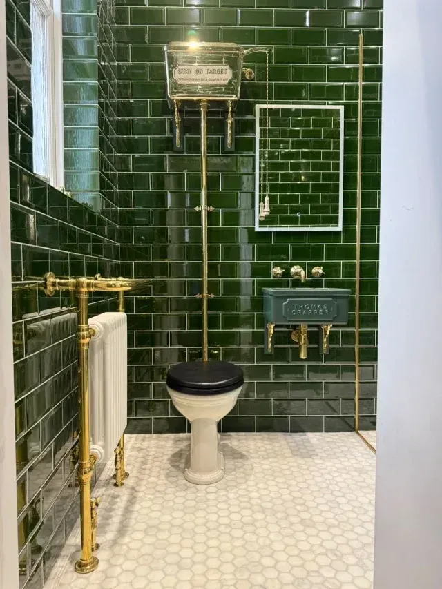 Traditional bathroom featuring a Thomas Crapper high-level toilet, polished brass pipework, green metro tiles and heritage styling by Island Bathrooms.